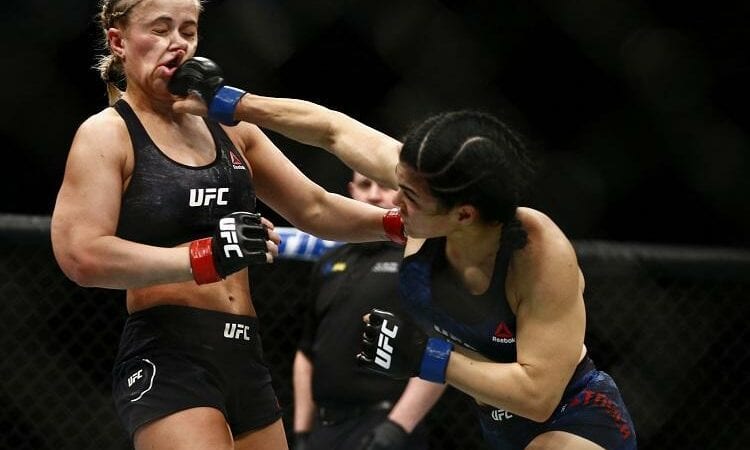 Ostovich competed two months after suffering orbital injuries in a domestic violence incident in Hawaii. The UFC was heavily criticized in the leadup to the bout for placing Ostovich on the same card as convicted domestic abuser Greg Hardy. In a show of support, Ostovich was cornered by several family members for the bout rather than her trainers.